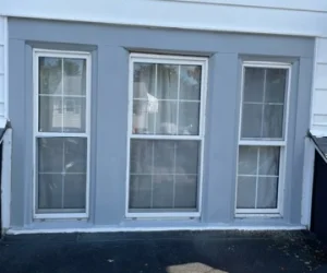 The exterior of a residential home in Delaware County, PA painted light gray around the windows