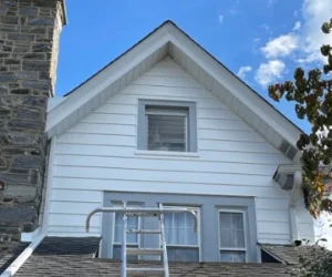 The exterior of a residential home in Delaware County, PA painted light gray around the windows