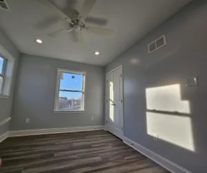 A residential bedroom in Delaware County, PA with a fresh coat of light gray paint